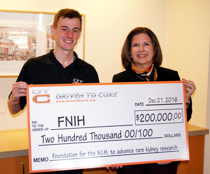 Andrew Lee, Driven to Cure President and CEO, presents the donation to Maria C. Freire, FNIH President and Executive Director, at an event held today at NIH.